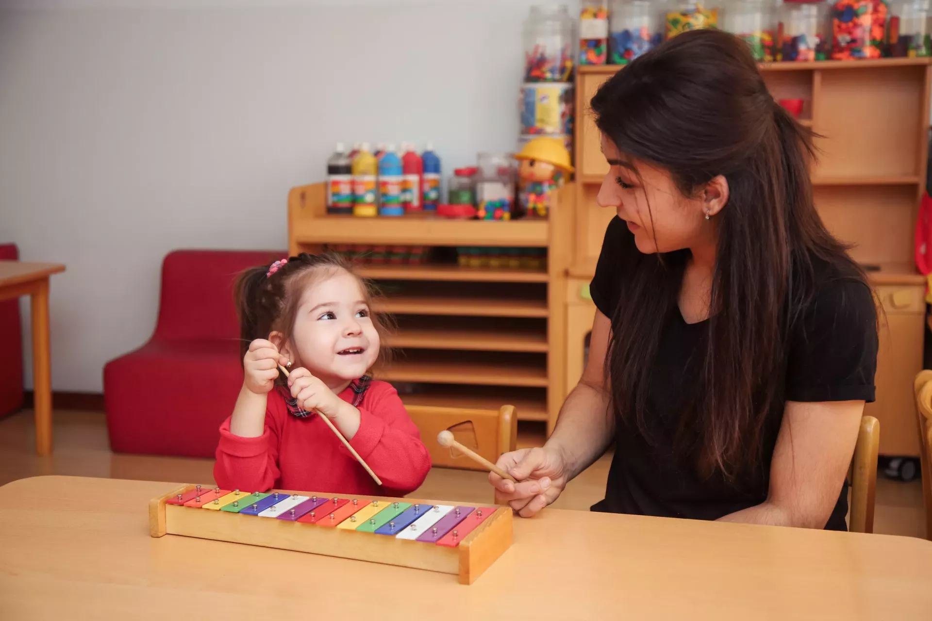 A mother playing musical instrument with her daughter