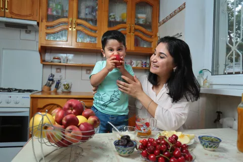 a baby boy eating an apple 
