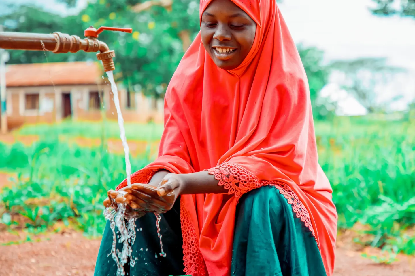 Tausi Katambarai fetching clean drinking water installed in the community through the generous support of the Grundfos Foundation.