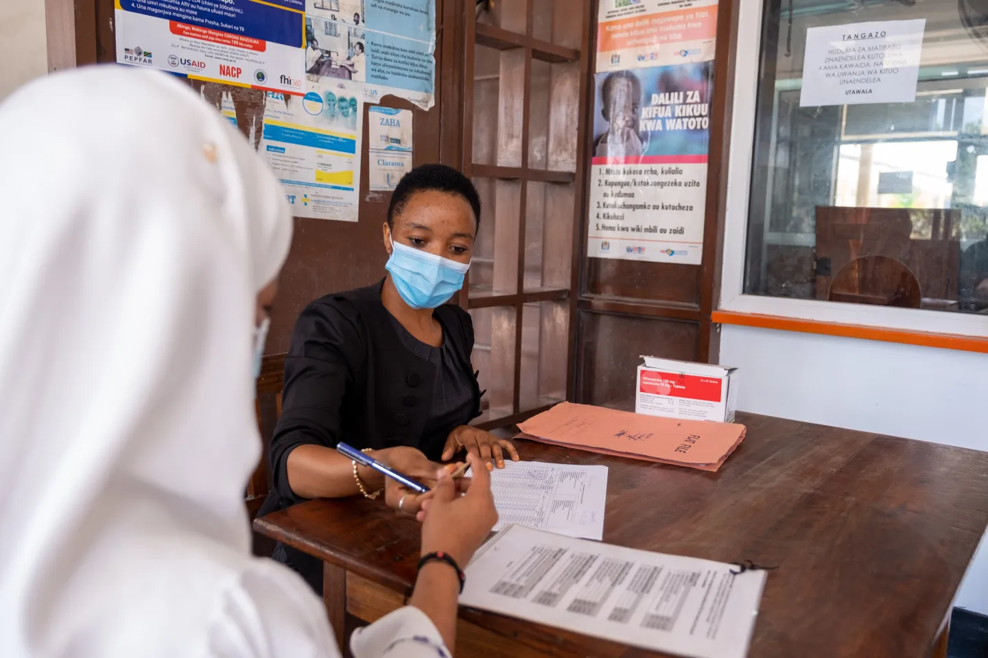Two women having a discussion at a medical facility in Tanzania.