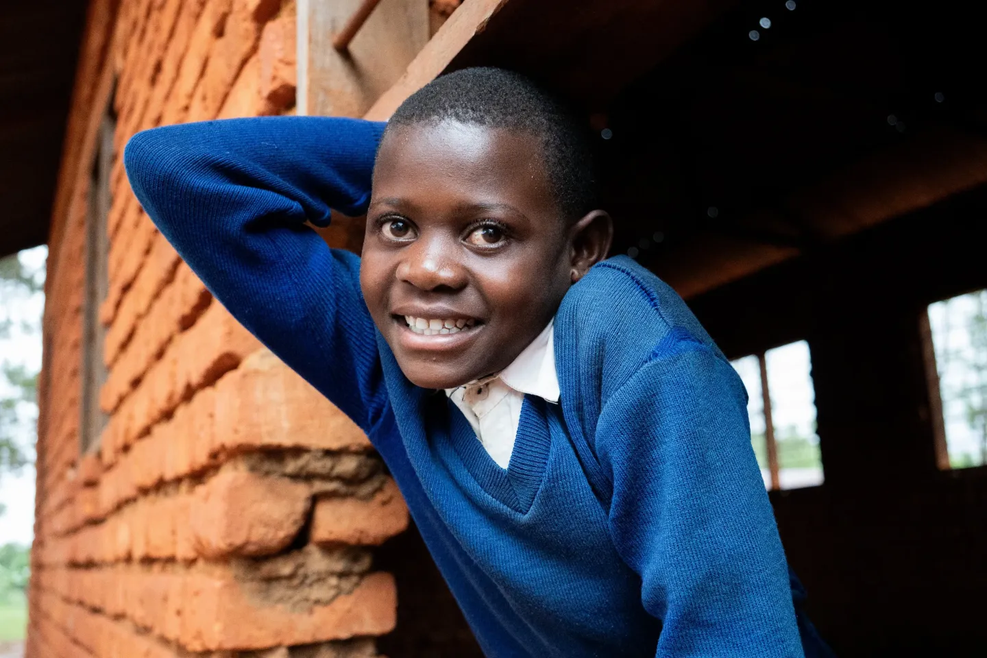 Magdalene, 12, smiles at her school in Twabagondozi village, Kigoma Region, Tanzania. With access to daily nutritious meals, she now has the energy to learn, play, and lead among her peers.