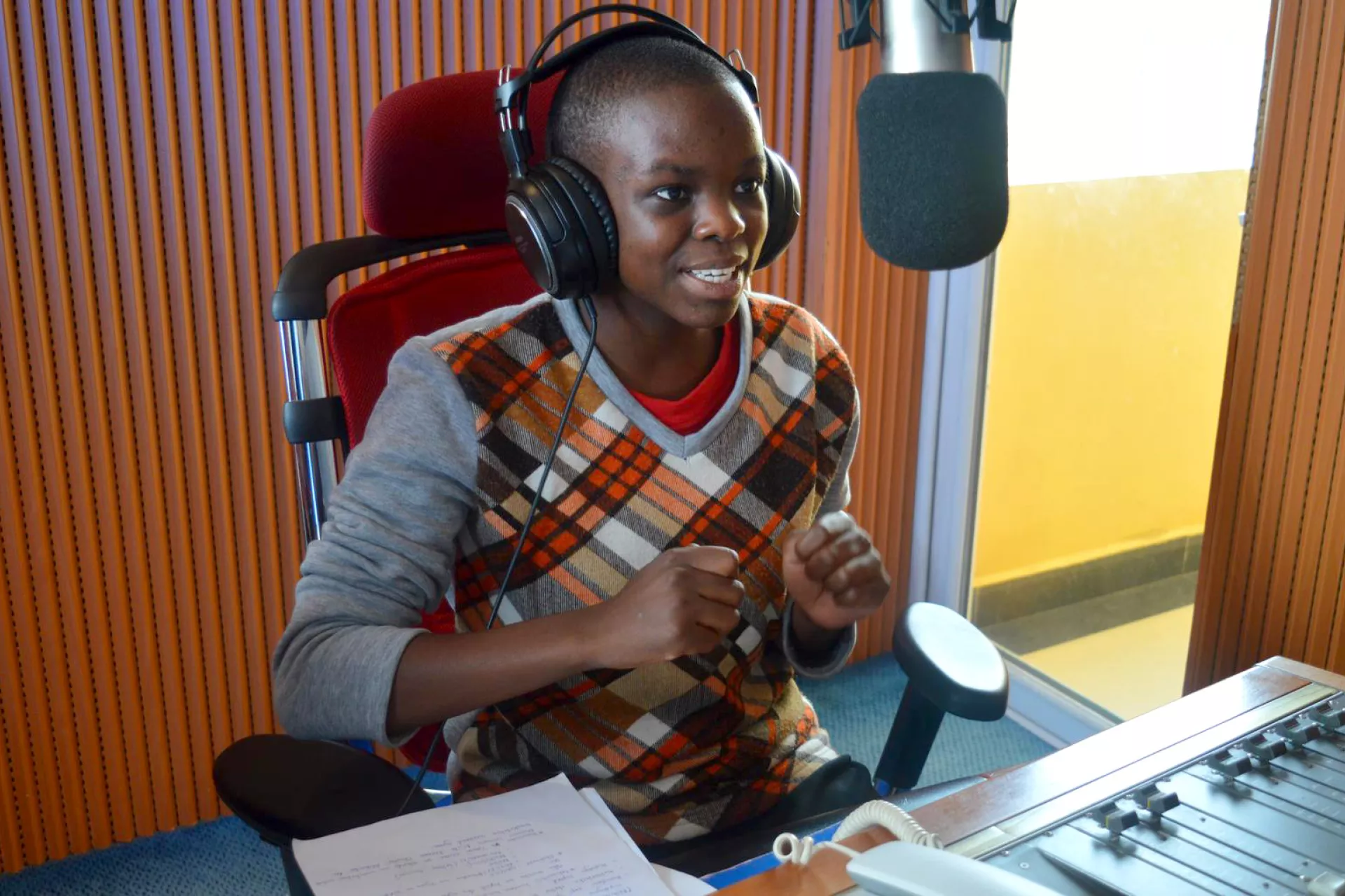 16 year old reporter sits at radio microphone