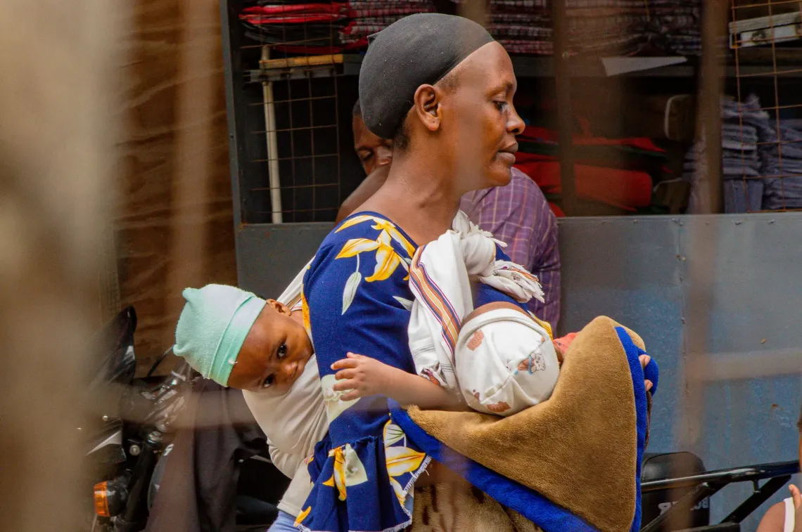 With both hands full, Salome moves through the market 