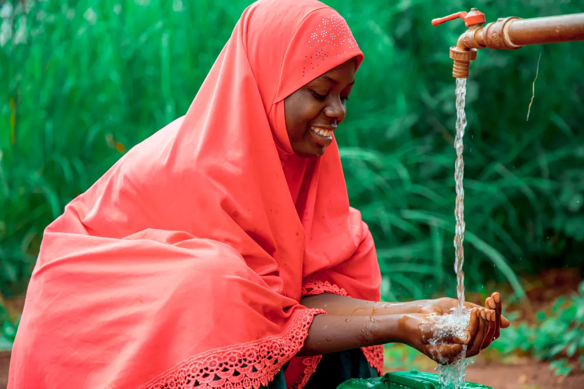 Tausi Katambarai fetching clean drinking water installed in the community through the generous support of the Grundfos Foundation.