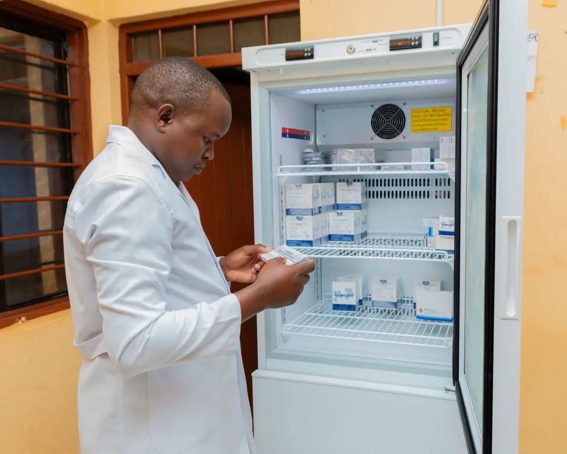 Dr Yohana Charles Iganyenga checks vaccines and blood supplies stored in temperature-controlled refrigerators at a health facility in Kishapu District.