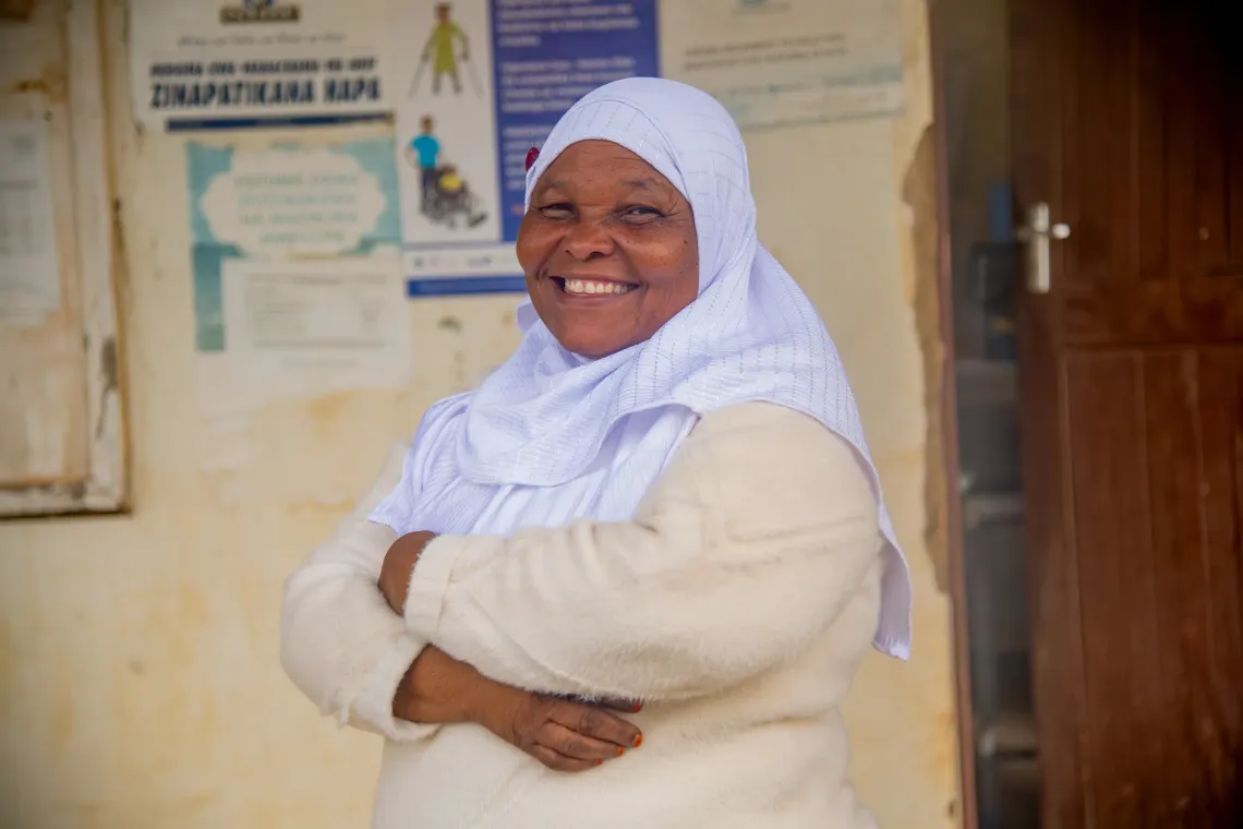 Sikitu Omary, standing, smiling with her arms crossed.