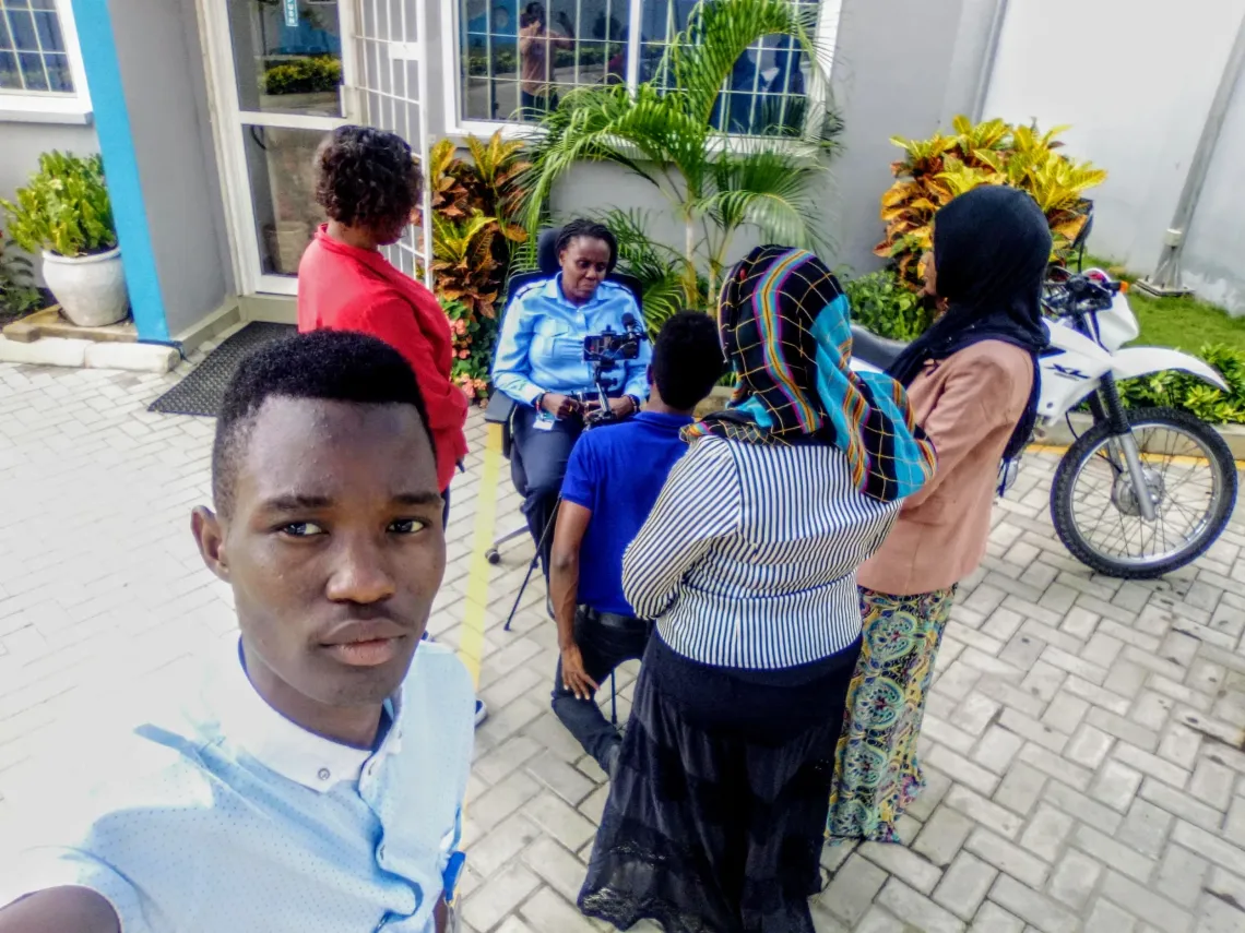 Rashid Malekela and fellow digital storytellers collaborating in a group, producing an interview with a UNICEF security officer as part of their practical work during a digital storytelling workshop in Dar es Salaam. 