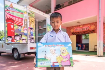 A school boy is holding his favourite book.