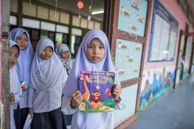 A school girl is holding her favourite book.
