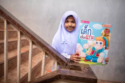 A school girl is holding her favourite book.