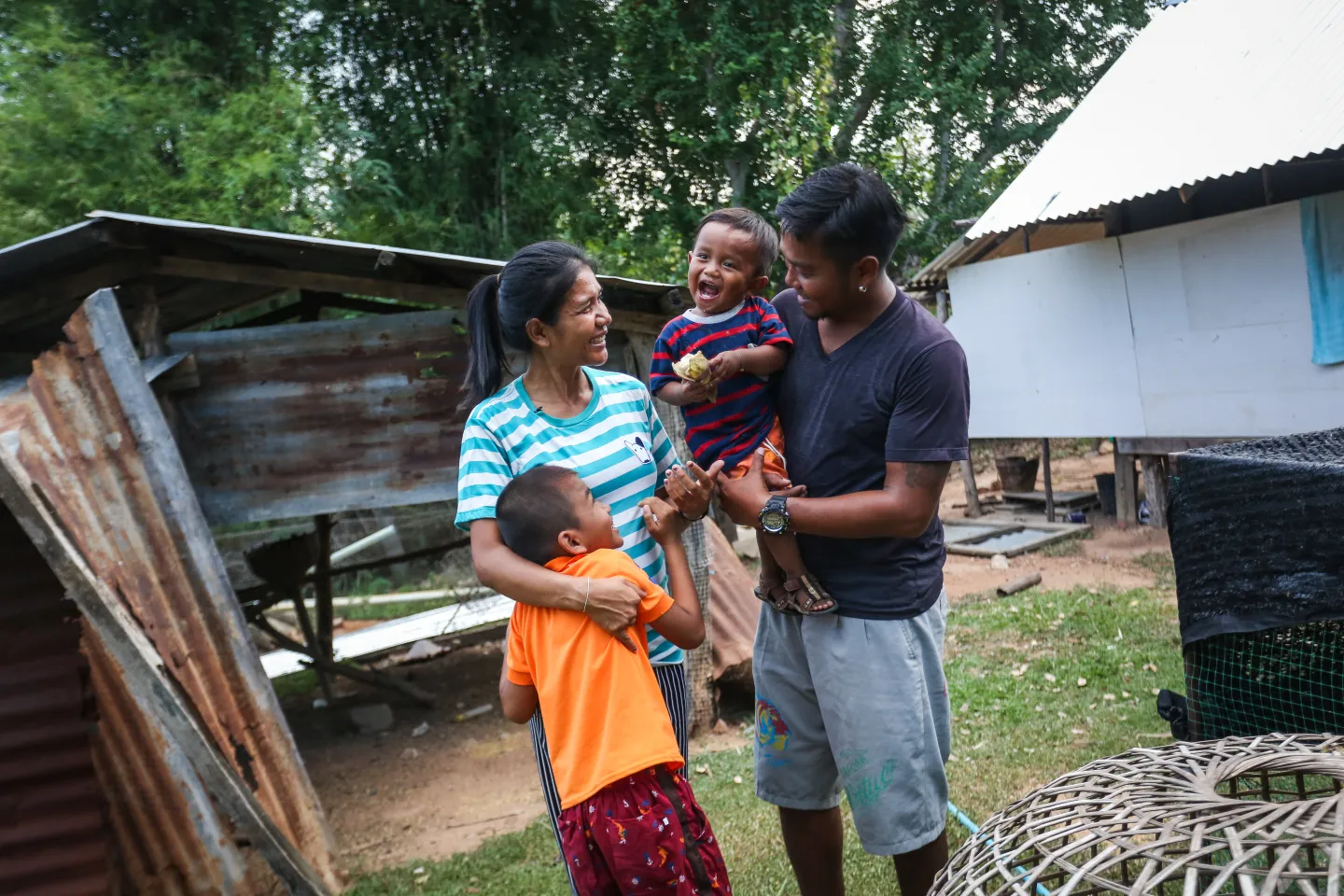 A mother and father smiling with their two children