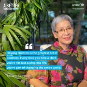 An elderly woman with short gray hair is smiling while wearing glasses and a black floral dress with vibrant red and purple flowers. She is seated outdoors in a garden-like setting with lush green plants surrounding her. The image includes a quote. Additional text reads &amp;quot;A Better Tomorrow Today&amp;quot; in the top left corner and &amp;quot;UNICEF for every child&amp;quot; in the top right corner.