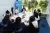 กลุ่มเยาวชนหนุ่มสาวกำลังนั่งประชุมในห้องประชุมที่ออฟฟิศยูนิเซฟ ที่มุมห้องมีป้ายผ้าโลโก้ยูนิเซฟวางอยู่