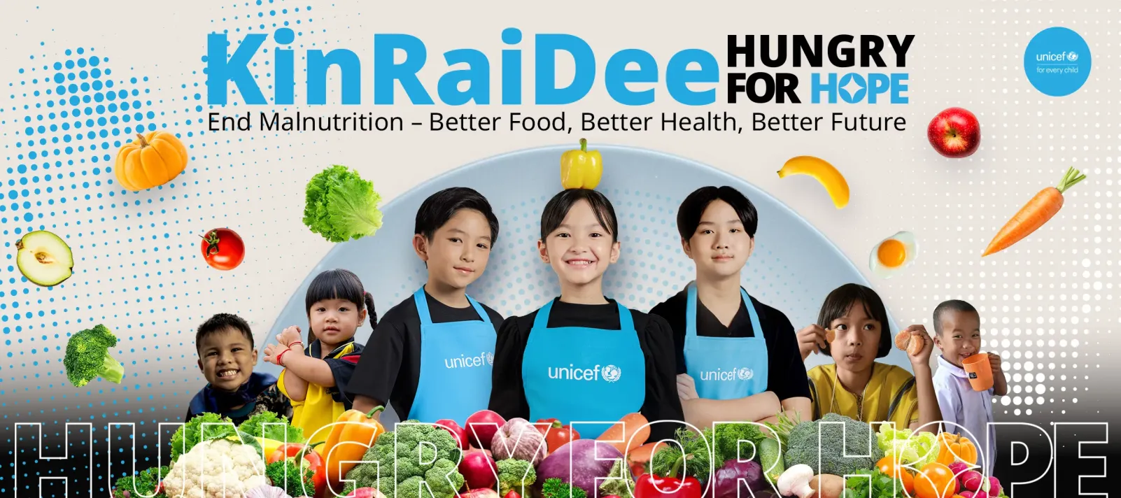 Children wearing UNICEF aprons stand smiling among colorful vegetables and fruits. Image contains text: "KinRaiDee Hungry for Hope &ndash; End Malnutrition: Better Food, Better Health, Better Future."