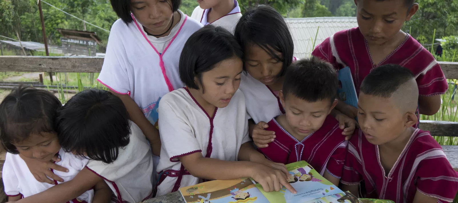 A group of hilltribe children are reading books from mobile library