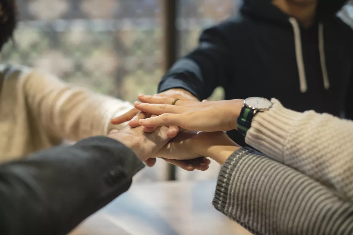 People are joining hands to symbolize the willingness to work together.