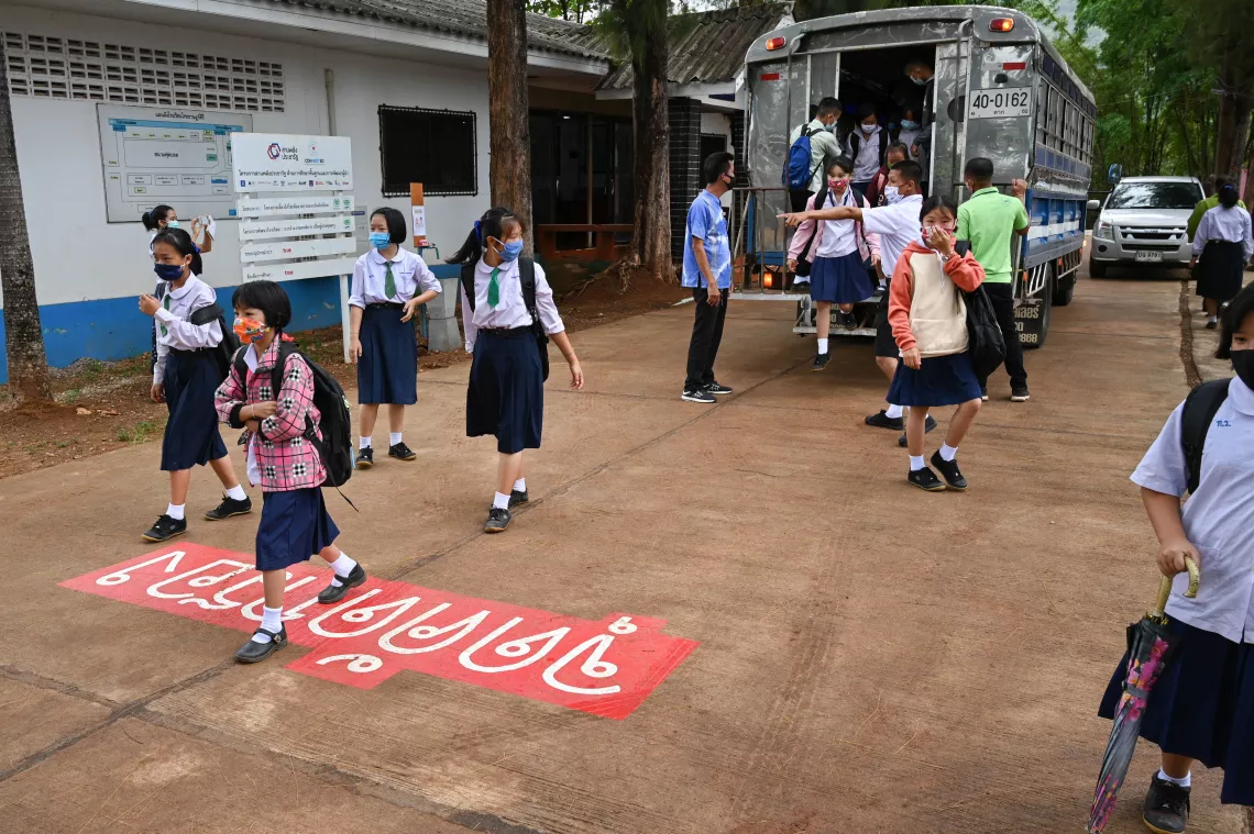 Students are getting of the school bus and are walking to the screening area.