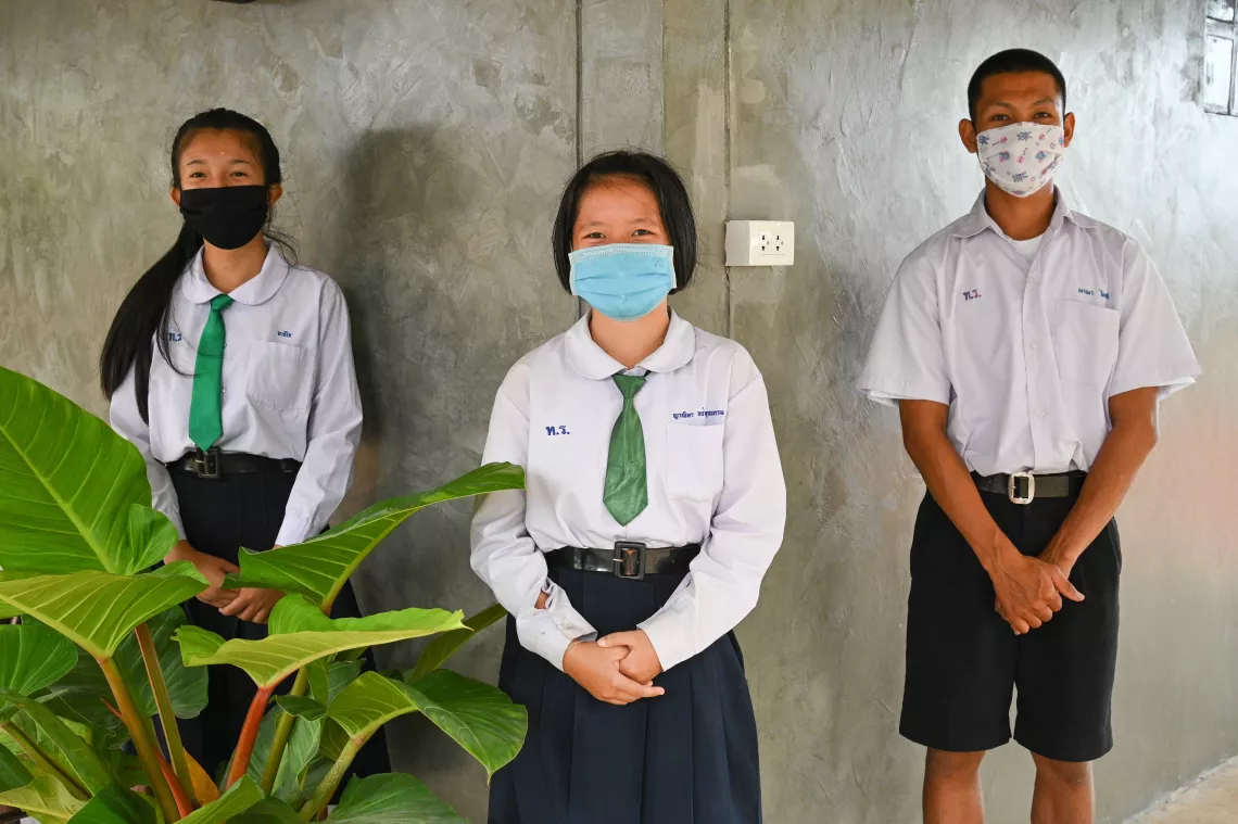 Three students in their student uniform, wearing face mask.