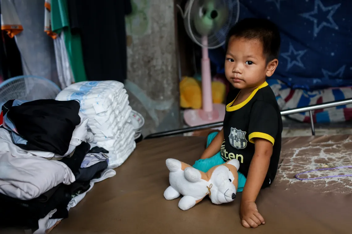 A boy sitting on his mother's bed