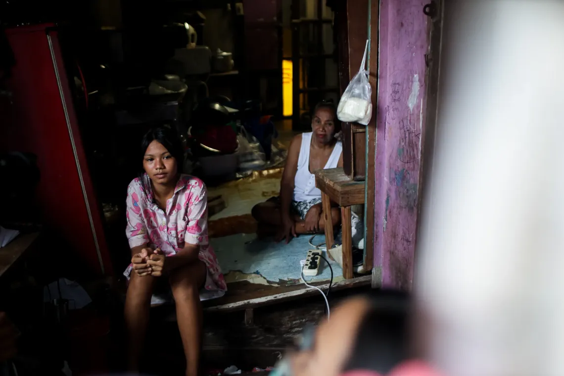 Teenager and her grandmother are sitting in their own dark house.