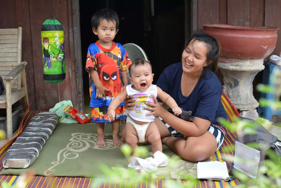A mother and her two children in front of her house