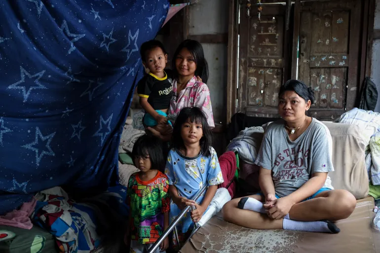 A mother and four children in their house.