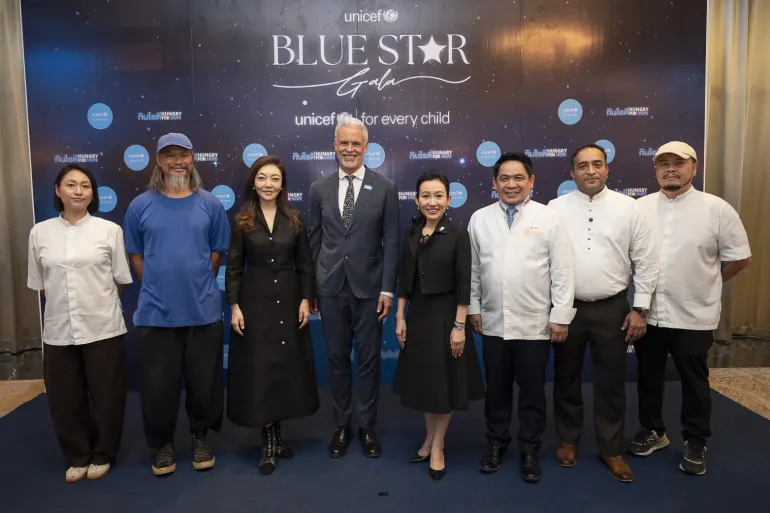 A group of adults pose together at a formal event in front of a backdrop that reads &ldquo;UNICEF Blue Star Gala,&rdquo; with event logos and the message &ldquo;for every child&rdquo; displayed behind them.