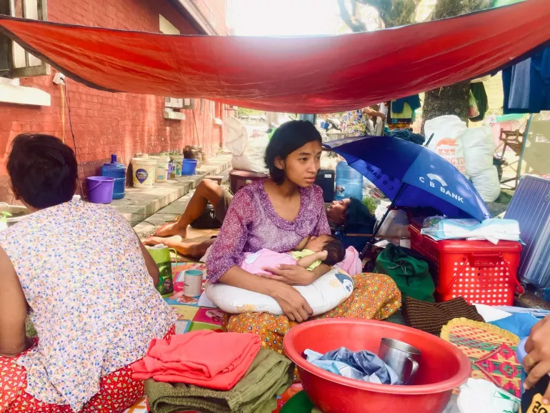 Children and families take shelter in makeshift outdoor spaces.