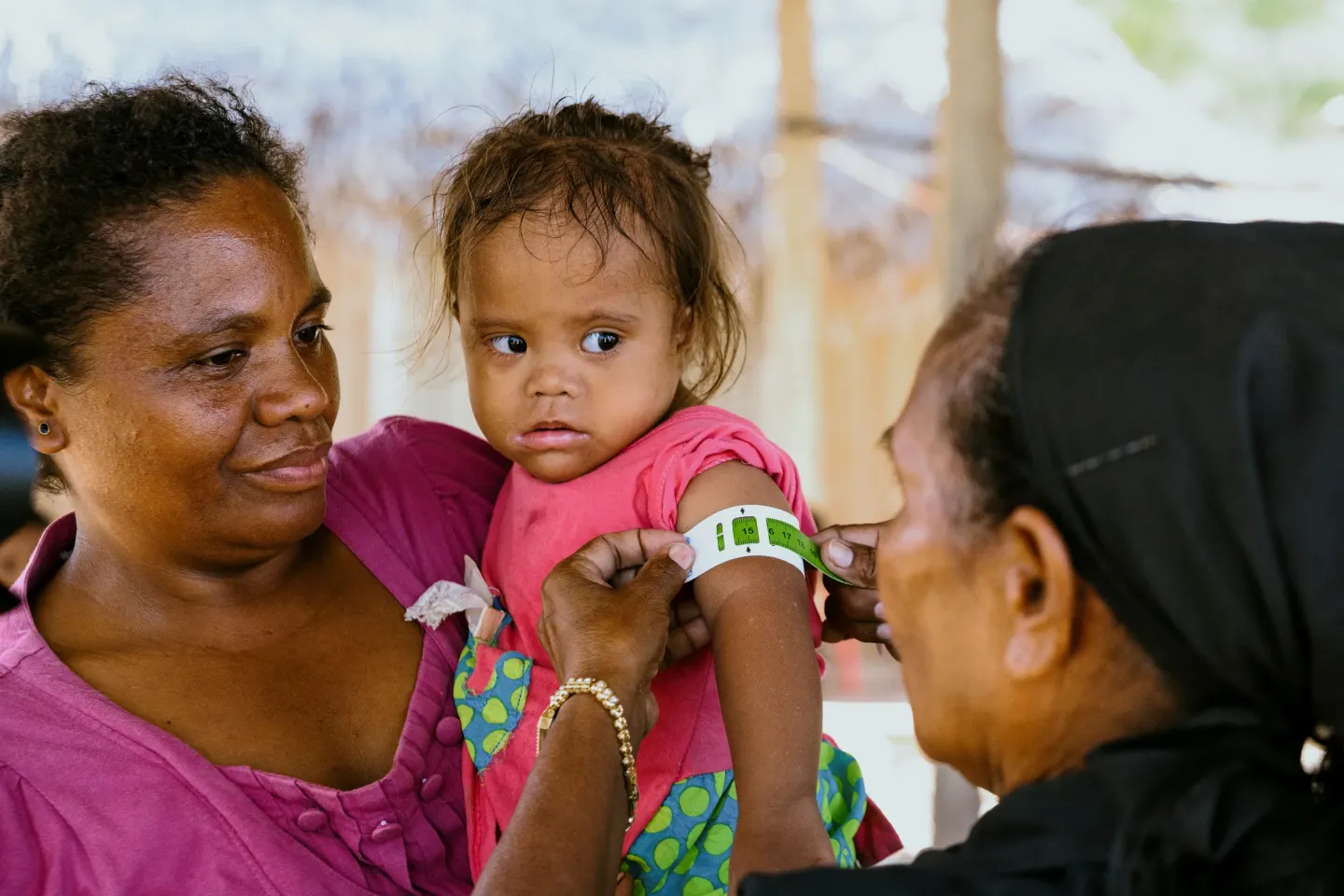 Adriana has her arm circumference measured at a community health outreach session