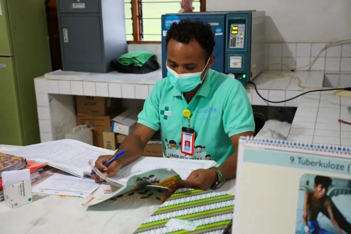 Nurse Sim&atilde;o is filling in Maia&rsquo;s Mother and Child handbook. 