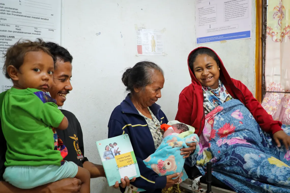 Newborn Maia is being celebrated by her family while her father holds her &lsquo;Mother and Child Health Handbook&rsquo;. 
