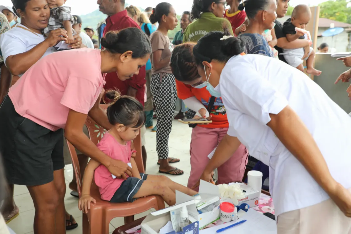 Mother Delfina takes Zenesia to each station at the outreach service.