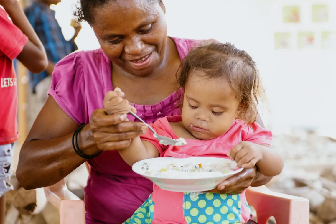 Adriana eats rice cooked by members of the mother support group