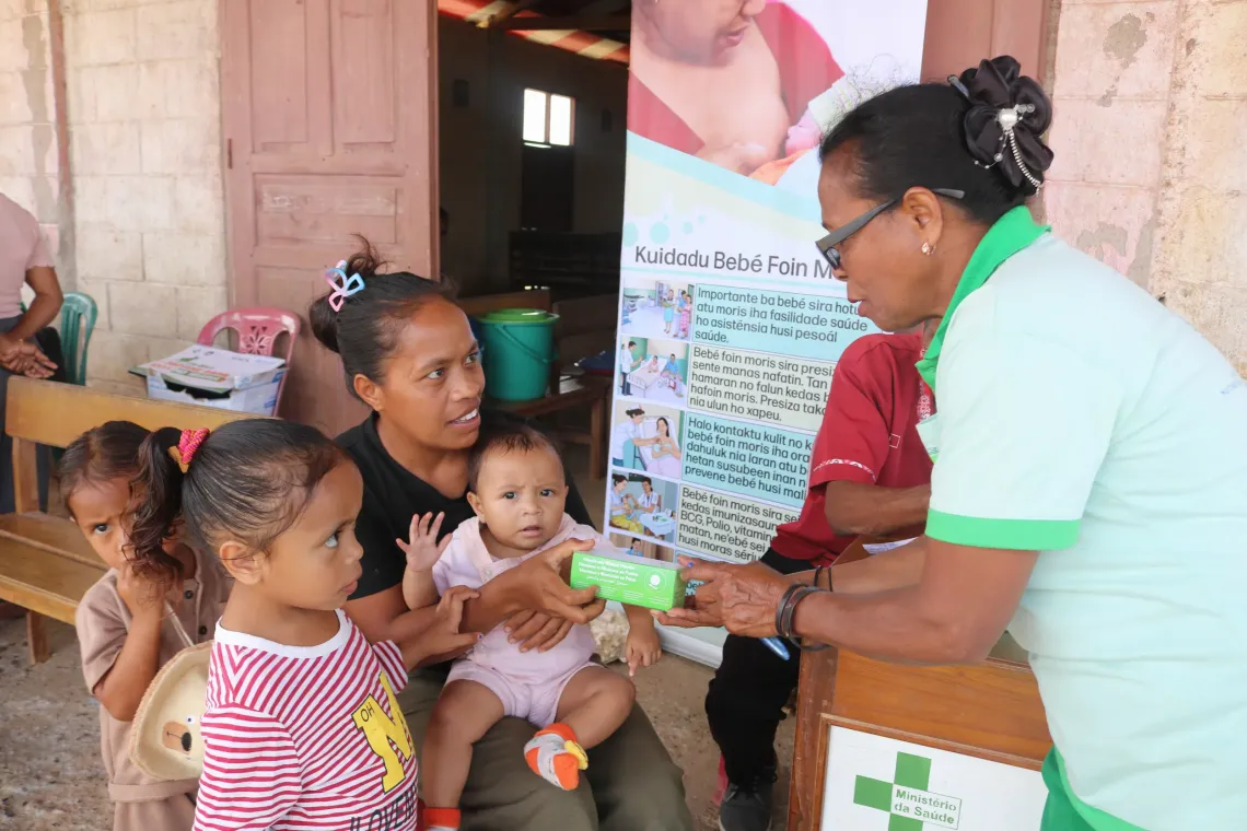 Miranda distributes micronutrient powder and explains how to cook porridge using local produce. 