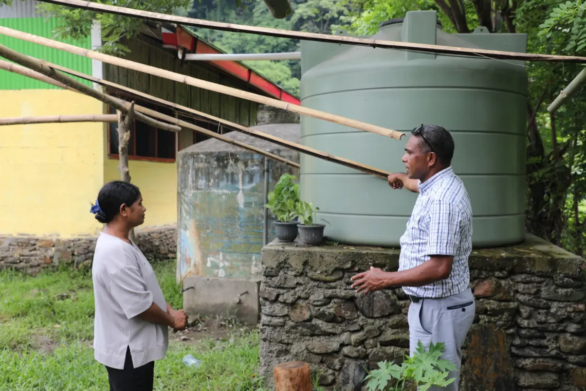 Marcelino Mendon&ccedil;a, School Inspector for Basic Education, monitors a rainwater harvesting tank with a school coordinator during a visit in school. 
