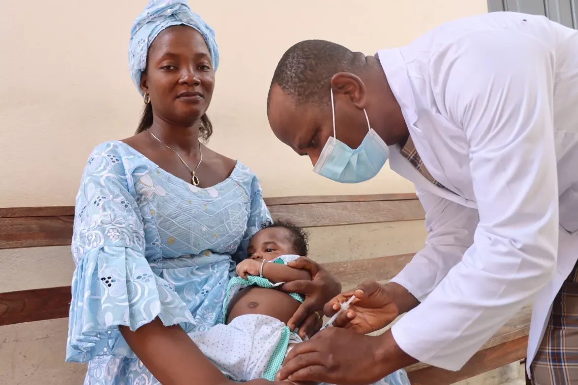 Ameyo HLONMETI fait vacciner son enfant Tr&eacute;sor de deux mois et deux semaines par Koku HEDIDO, Assistant d'hygi&egrave;ne de sant&eacute; publique charg&eacute; de la vaccination 