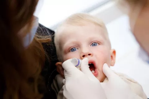 ウクライナのウジホロドにある医療センターで、母親のハンナさんに抱かれながらポリオワクチンの投与を受ける1歳のミロンくん。