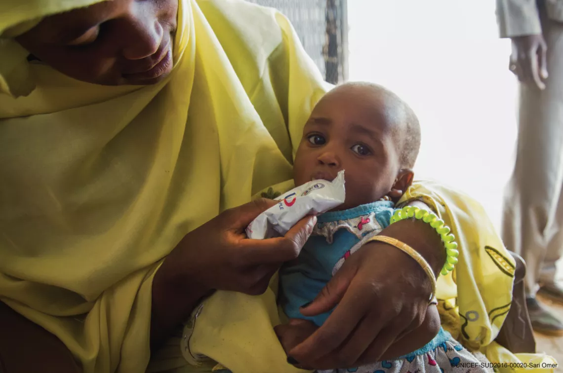 平成27年度補正予算から国内避難民への栄養支援事業が行われたスーダンより、重度の急性栄養不良から回復しつつある子どもに栄養治療食（RUTF)を食べさせる母親。