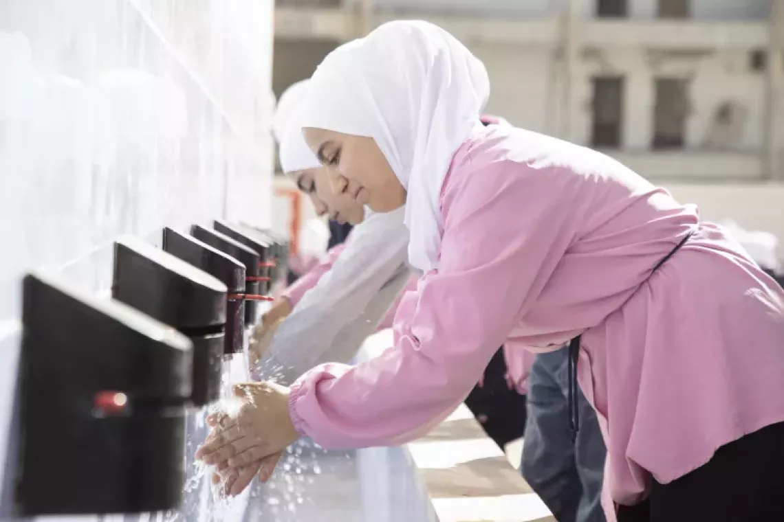 Zeina, 13, and her friend Sham wash their hands in the yard of a UNICEF-rehabilitated school in Irbeen, Rural Damascus.