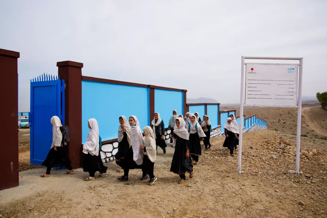 新しく建設された学校に登校するソロビ女子学校の生徒たちが、校門から中へ入る様子。