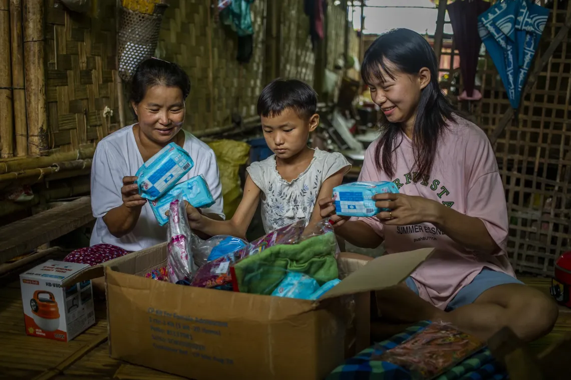 母親や妹と一緒に、UNICEFから受け取った子どもの保護キットを開けるキャンさん。