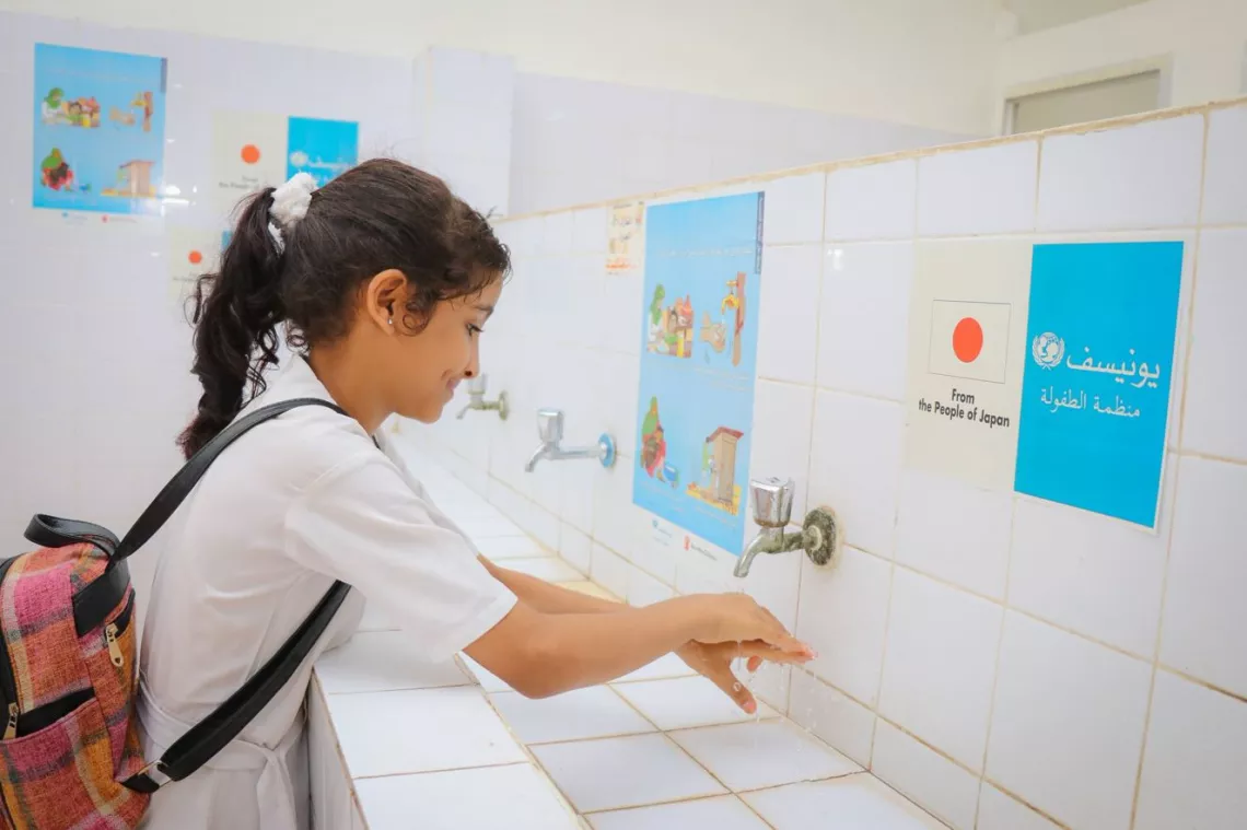 子どもたちの健康を守り、学校の水と衛生施設の改善を行うためにUNICEFによって新たに改修されたトイレで手を洗う、イエメン・アデンのレイダン学校に通う生徒