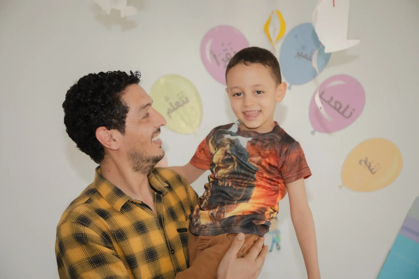 A father holding his son in a nursery.