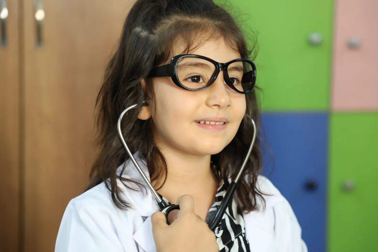 Little girl wearing doctor glasses.  