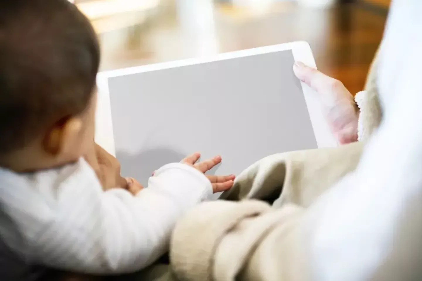 Annesiyle tablet ekranına bakan bir bebek 