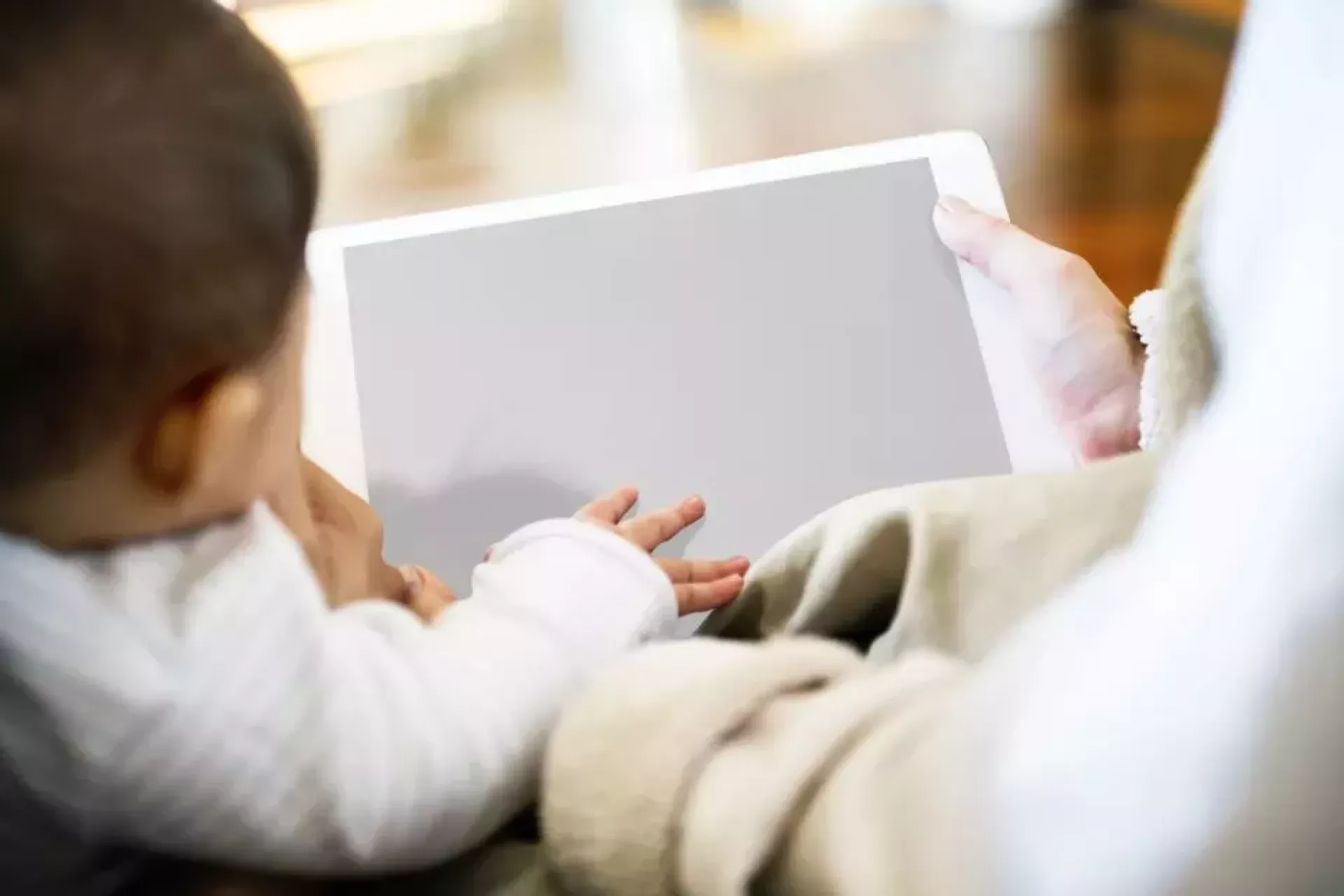 Annesiyle tablet ekranına bakan bir bebek 