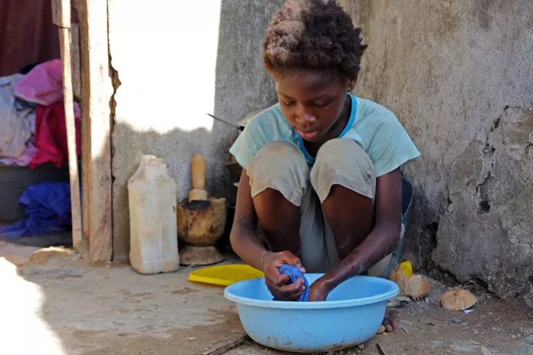 A child in a coastal town in Grand-Anse Department, Haiti, washes their hands.