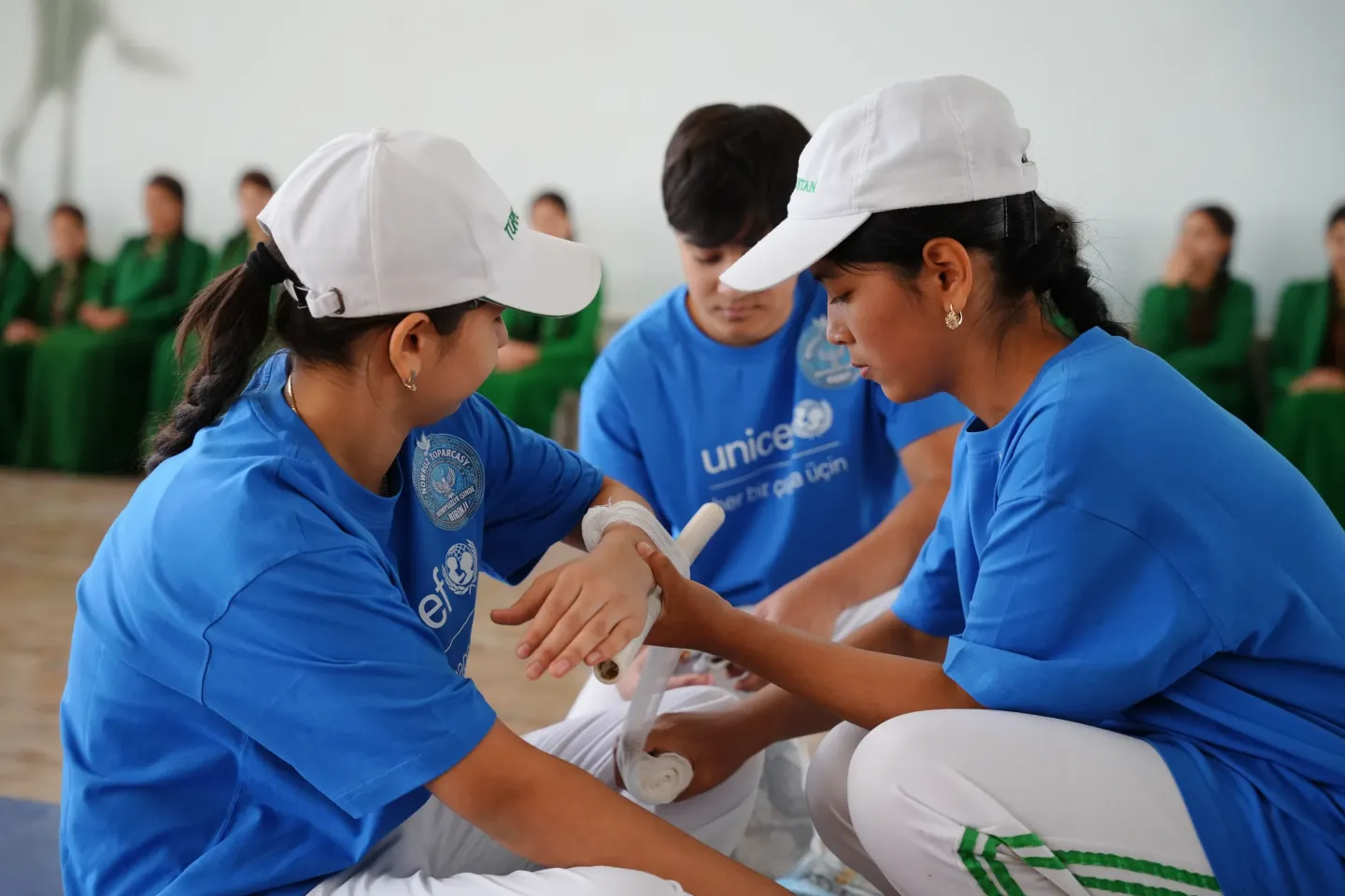 Participants practise first-aid techniques as part of an emergency preparedness exercise. Practical training helps young people understand how to respond appropriately in an emergency and support others safely.
