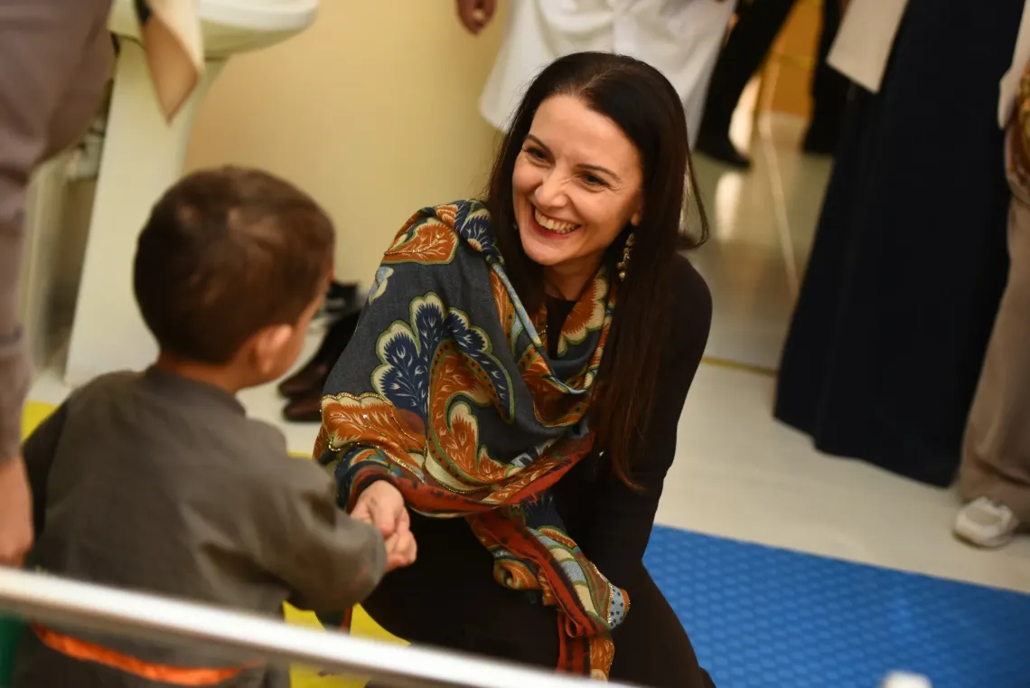 a woman greeting a child