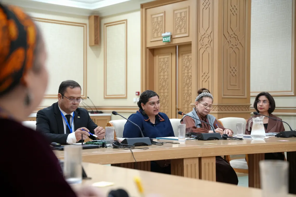 NICEF Representative Jalpa Ratna speaking into a desk microphone during a panel session with government and education partners.